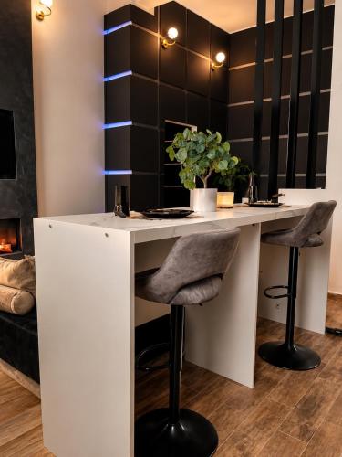 a white desk with two stools in a room at Rebecca's Noir Suite in Reggio Emilia