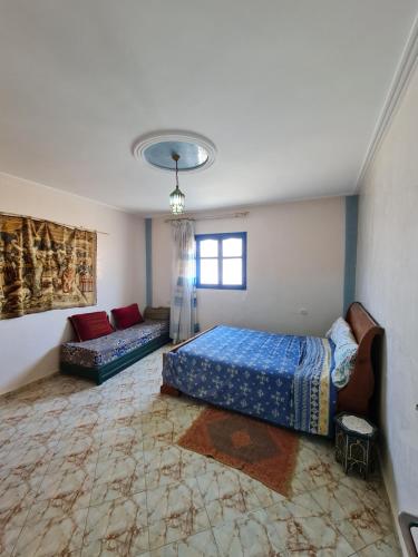 a bedroom with two beds and a couch in it at Banana Aourir in Aourir