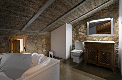 a bathroom with a tub and a toilet and a sink at L'Antic ajuntament de la Torra in La Baronia de Rialb