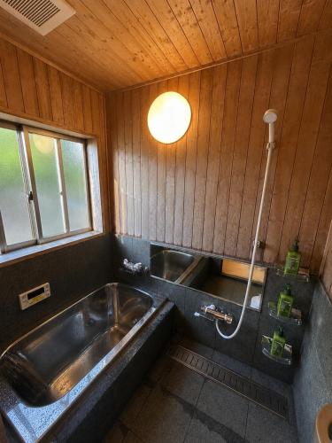 a bathroom with a sink and a bath tub at 小さなペンション Branchee in Kushimoto