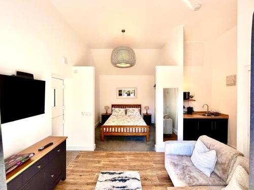 a living room with a bed and a couch at Hideaway Suite in Ambleside