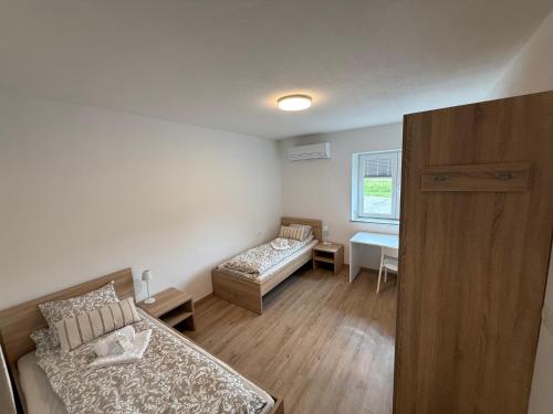 a small room with two beds and a table at VP sobe in Ilirska Bistrica