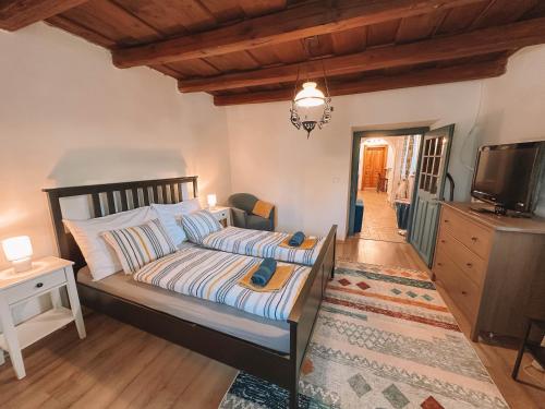 a bedroom with a bed and a television and a table at Három Dió Vendégház in Nyim