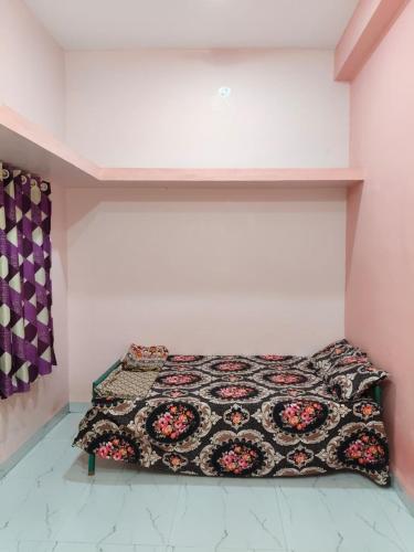 a bedroom with a bed with a quilt on it at Swami's Yatri nivas in Akalkot