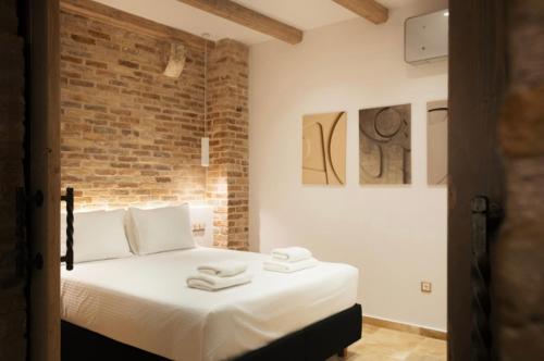 a bedroom with a bed with two towels on it at Arco Segreto Apartment, Old Town in Corfu