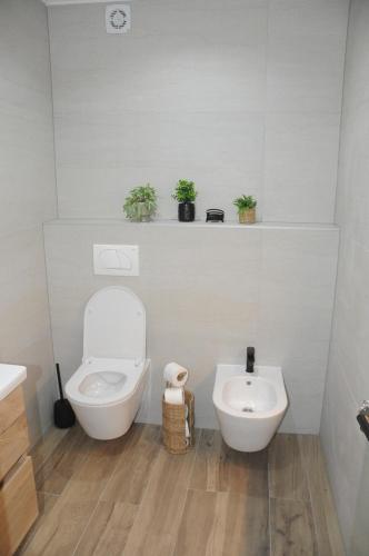 a white bathroom with a toilet and a sink at Villa Lapis in Mostar