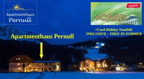 a view of a resort at night with the text card holidays peruvian peninsula at Apartmenthaus Pernull in Tröpolach