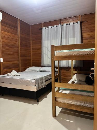 a bedroom with two bunk beds and a window at HolzHaus em Pomerode in Pomerode