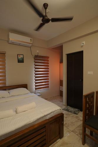 a bedroom with a bed and a ceiling fan at Blue Pearl Residency in Trivandrum