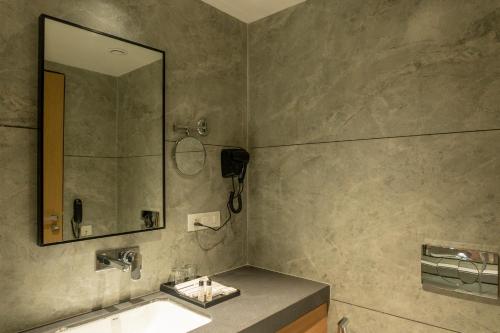 a bathroom with a sink and a mirror at Pride Elite Himmatnagar in Sonāsan