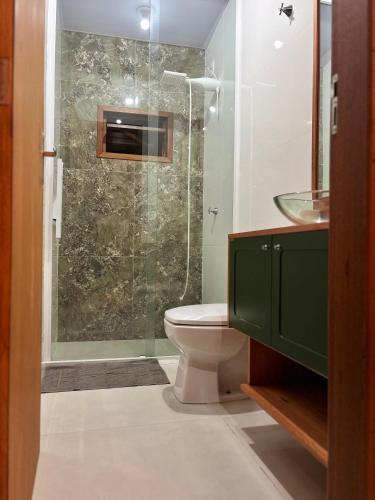 a bathroom with a toilet and a glass shower at HolzHaus em Pomerode in Pomerode