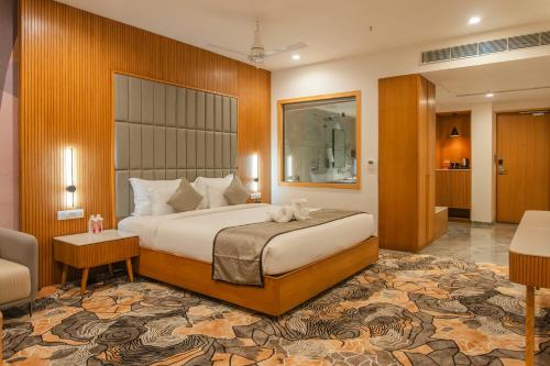 a hotel room with a bed and a living room at Pride Elite Himmatnagar in Sonāsan