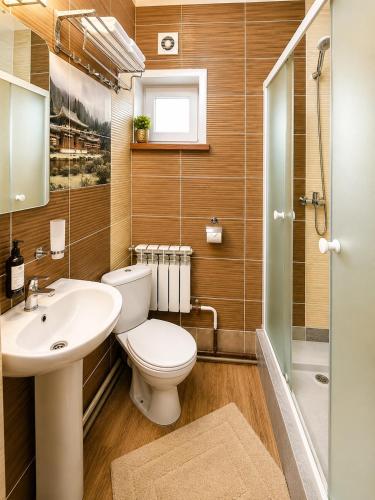 a bathroom with a toilet and a sink and a shower at VIP Mini Hotel in Semey