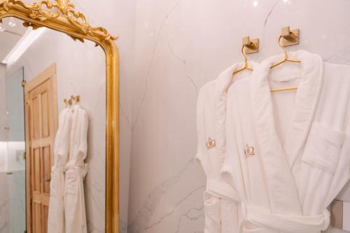a mirror in a bathroom with white clothes on hangers at Hotel Casa Huamantla in Huamantla
