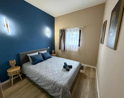a bedroom with a bed with blue walls at Loft Tolosa - Clim & Parking Privé Toulouse Nord in Rouffiac-Tolosan
