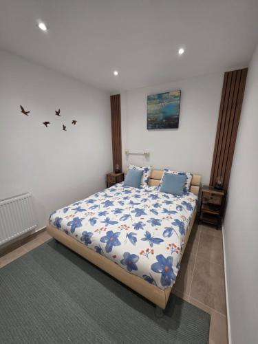a bedroom with a bed with a blue and white comforter at Hillside Home in Magyarhertelend