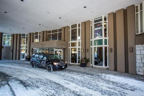 a car parked in front of a building in the snow at Le Chamois by Whistler Premier in Whistler