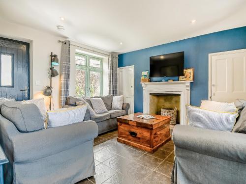 a living room with two couches and a tv at Greenrush Cottage in Blakeney