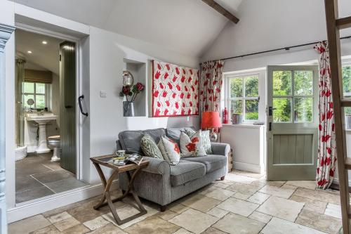 a living room with a couch and a table at Top Cottage, Oddington in Adlestrop