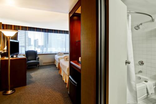 Cette chambre d'hôtel dispose d'une salle de bains avec un lit et une baignoire. dans l'établissement Chateau Lacombe Hotel, à Edmonton