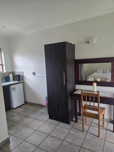 a kitchen with a desk and a table in a room at Fantasy Farmyard Guest House in Randfontein