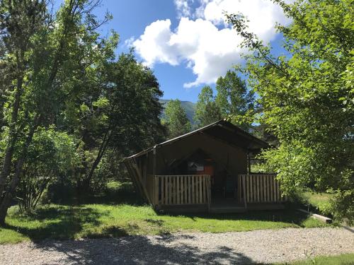 a cabin in the middle of a field with trees at Camping Lou Passavous in Le Vernet
