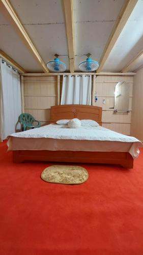 a bedroom with a large bed with a red carpet at Keyangjhiri Eco Resort, Lama, Bandarban in Bāndarban