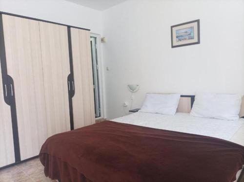 a bedroom with a large bed and a window at Capri Family Hotel in Primorsko