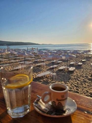 a table with a glass of water and a cup of coffee at Capri Family Hotel in Primorsko