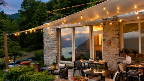 a patio with tables and chairs and lights at Essentia Guest House in Faggeto Lario 