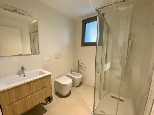 a bathroom with a toilet and a sink and a shower at Cozy flat 300m from the beach in Bibione