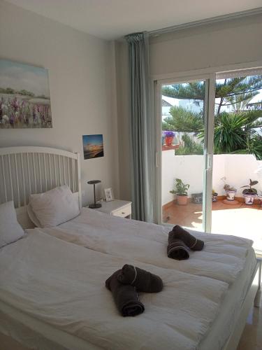 a bedroom with a bed with two brown towels on it at Elviria Beauty by the sea in Marbella