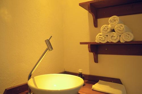 a bathroom with a sink and a lamp and towels at Residencial Vila do Sol, Apartamentos com pé na areia in Bombinhas