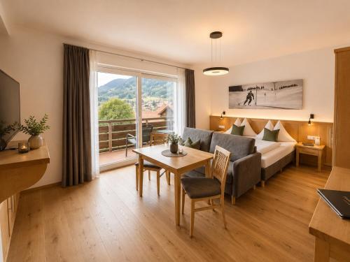 a living room with a couch and a table at MÜHLBACHER - inklusive kostenfreiem Eintritt in die Alpentherme in Bad Hofgastein