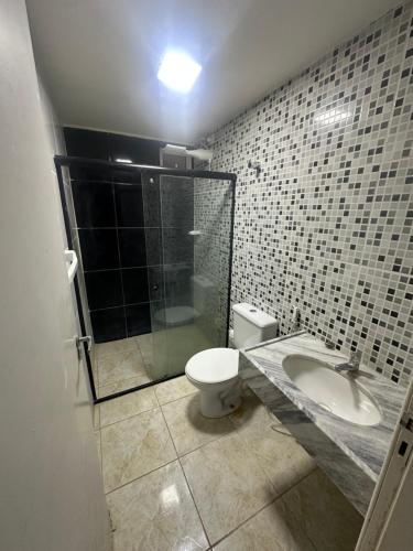 a bathroom with a toilet and a shower and a sink at Villa Marechais in Marechal Deodoro