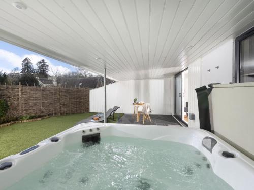 a large bath tub in a backyard with a table at Little Dunley Cottages - Hazel in Bovey Tracey