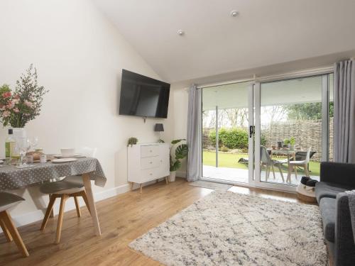 a living room with a dining table and a sliding glass door at Little Dunley Cottages - Hazel in Bovey Tracey