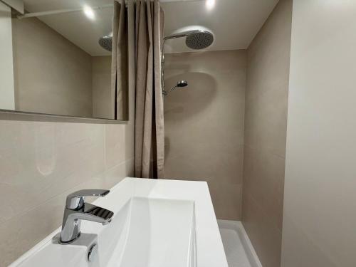 a bathroom with a white sink and a shower at Les Cabines de la Vie in Saint-Gilles-Croix-de-Vie