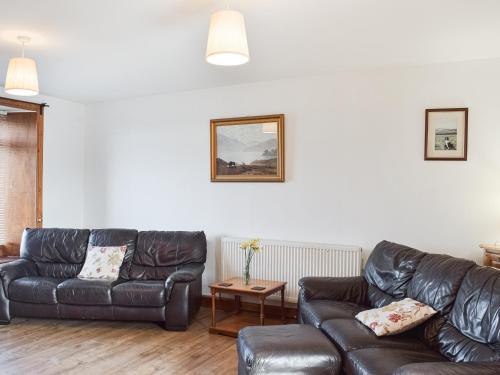 a living room with two leather couches and a table at Old Barn Cottage - Uk47144 in Glasgow