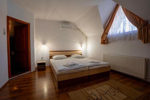 a bedroom with a bed and a large window at Casa Toma in Sovata