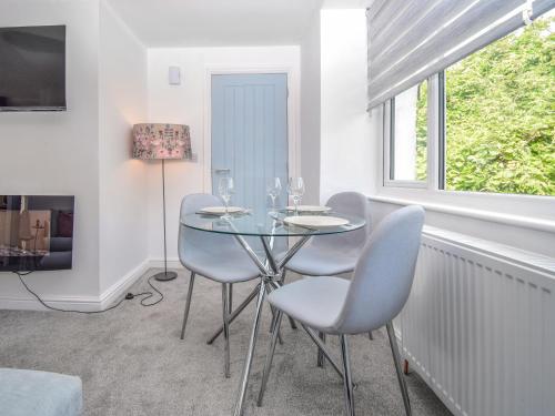 a dining room with a glass table and chairs at Old Chapel Apartment in Kendal