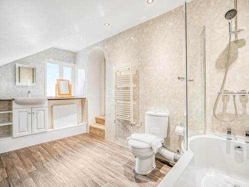 a bathroom with a toilet and a shower and a sink at Meadow Lakes in St Austell