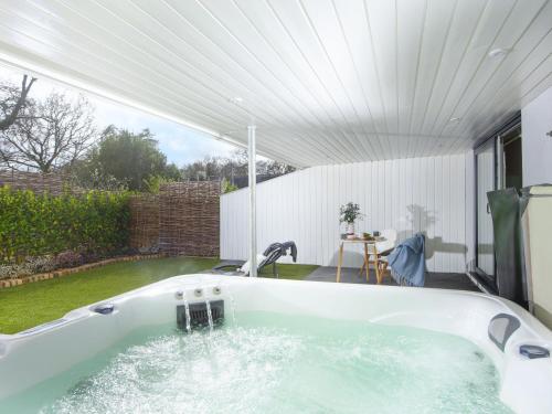 a large bath tub in a yard with at Little Dunley Cottages - Maple in Bovey Tracey