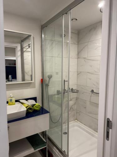 a bathroom with a glass shower and a sink at Orbi in Batumi 24 in Angisa