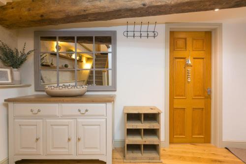 a kitchen with a white cabinet and a yellow door at The Moorings in St Ives