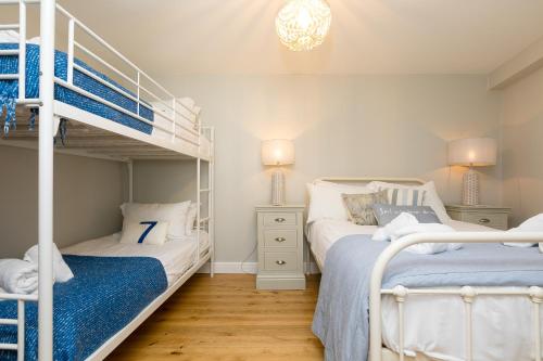 two beds in a room with two bunk beds at The Moorings in St Ives