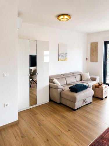 a living room with a couch and a mirror at Apartment ALBA in Medulin