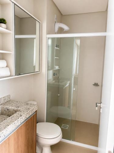 a bathroom with a toilet and a glass shower at Bocaiuva 139 - BeXap Stays in Chapecó
