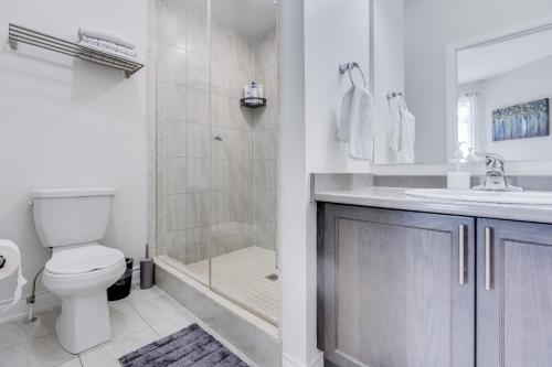 a bathroom with a shower and a toilet and a sink at Spacious Bright Private! Townhome in Markham in Markham