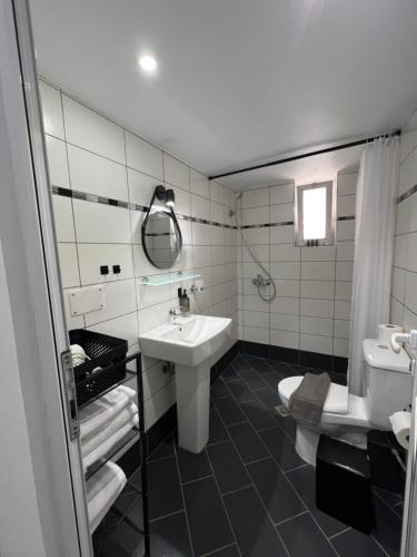 a white bathroom with a sink and a toilet at Spile Rooms Lukas in Himare
